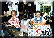 Picture of two women quilting a colorful quilt